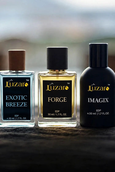 Luzaro perfume trio collection Exotic Breeze, Forge and Imagix EDP 50ml bottles in a row on dark textured stone surface with soft natural bokeh light background – luxury men’s fragrance collection lifestyle shot 1024x1535