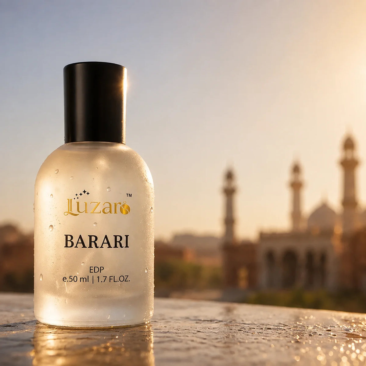 Luzaro Barari EDP 50ml frosted perfume bottle on wet stone surface at golden sunset with Badshahi Mosque minarets and dome blurred in background – 585x585 luxury fragrance lifestyle shot with water droplets and warm sunlight